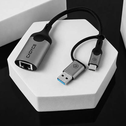 Close-up of Cadyce CA-CU1000 USB-A and USB-C to Gigabit Ethernet Adapter showing RJ45 port and dual USB connectors -tpstech.in