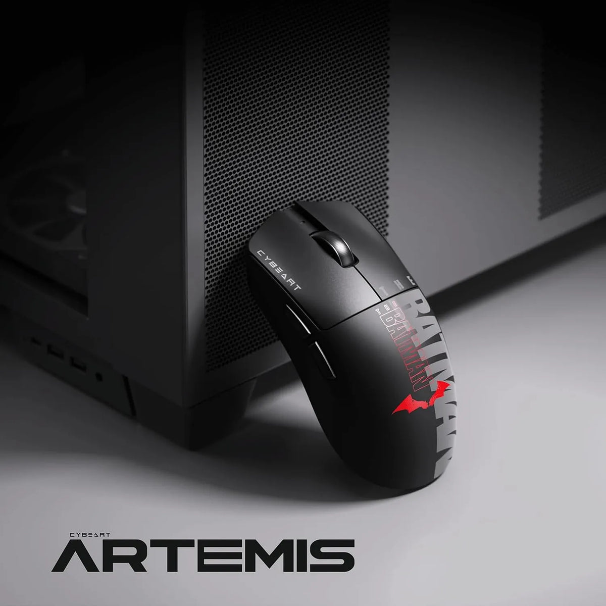 Cybeart Artemis The Batman 52g Ultra-Light Wireless Gaming Mouse placed beside a dark PC case -tpstech.in