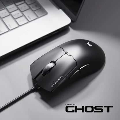 Cybeart Ghost 49g Ultra-light Wired Gaming Mouse placed on desk setup beside laptop -tpstech.in