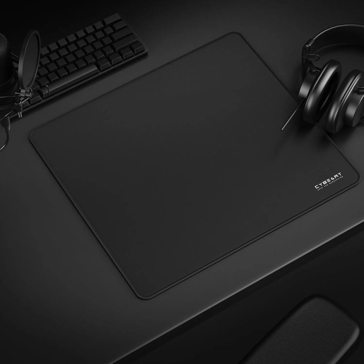 Cybeart Ghost large black gaming mouse pad set up on a gaming desk alongside keyboard and headphones -tpstech.in