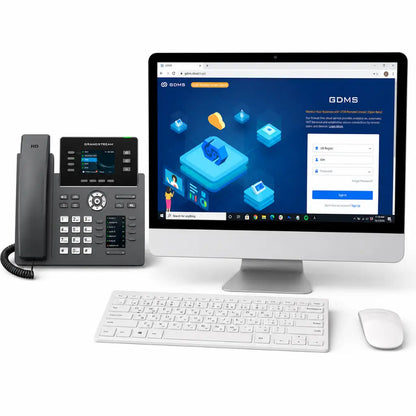 Grandstream GRP2614 professional IP phone connected with Grandstream Device Management System (GDMS) displayed on a desktop monitor in an office environment.