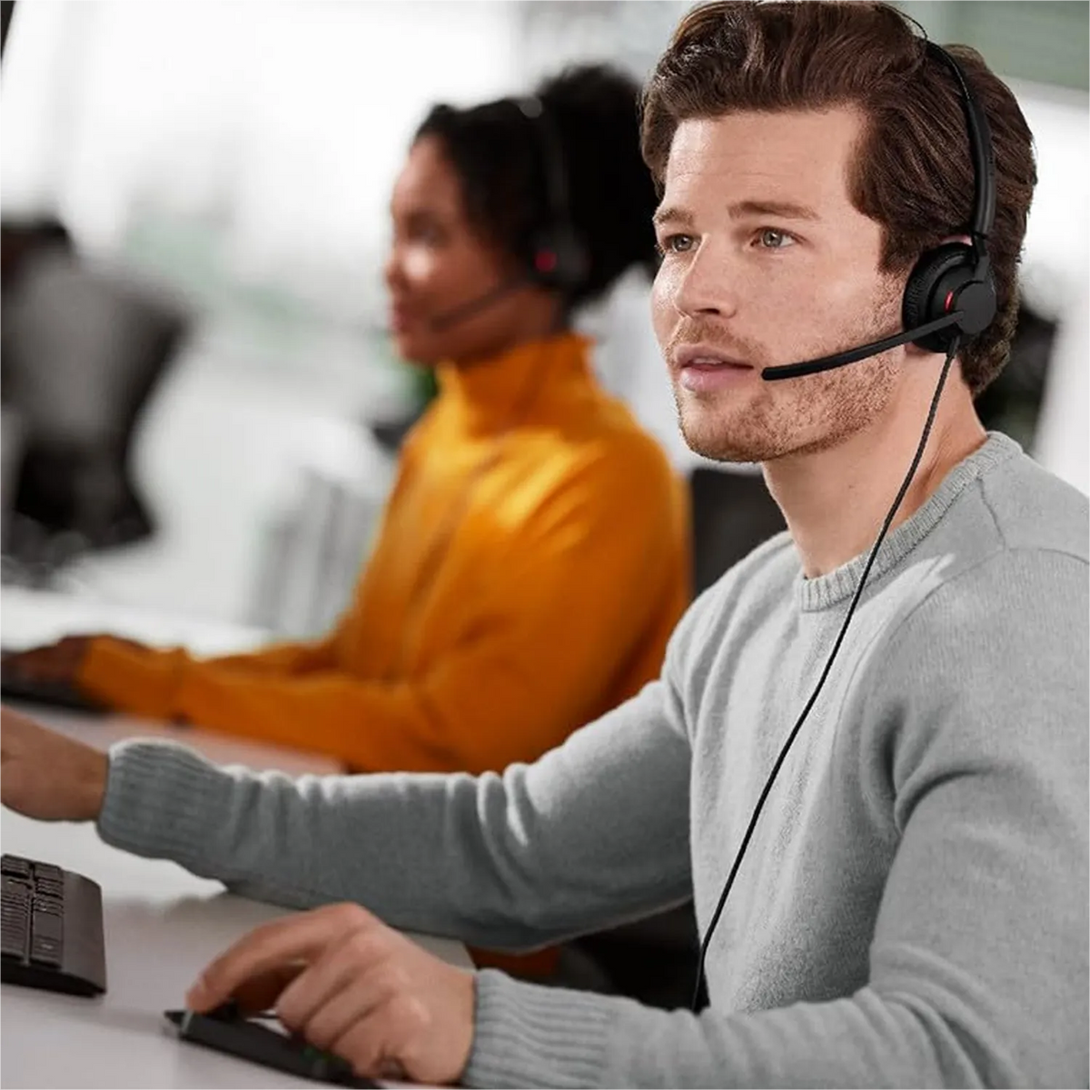 Customer support representative wearing Jabra Engage 50 II UC Stereo Headset in a busy call center office -tpstech.in