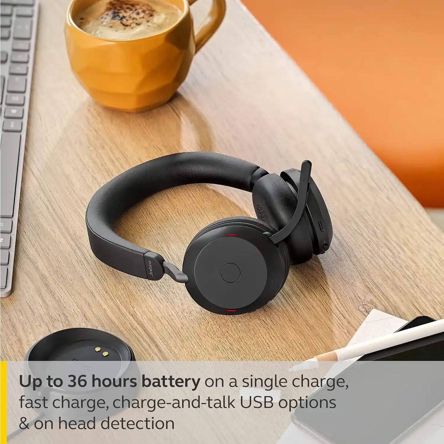 Jabra Evolve2 75 wireless headset offering up to 36 hours battery life placed next to charging base on wooden table -tpstech.in