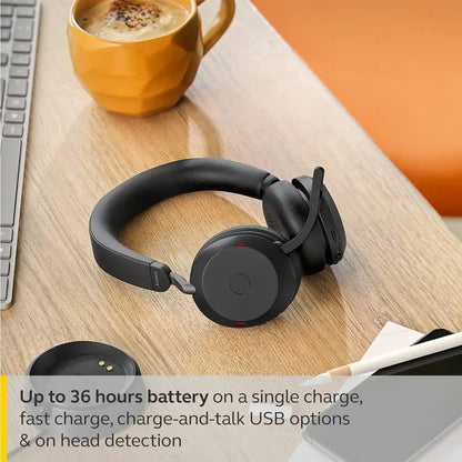 Jabra Evolve2 75 wireless headset offering up to 36 hours battery life placed next to charging base on wooden table -tpstech.in
