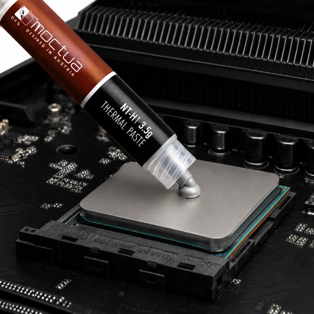 Noctua NT-H1 3.5g thermal paste being applied on a desktop CPU before cooler installation.
