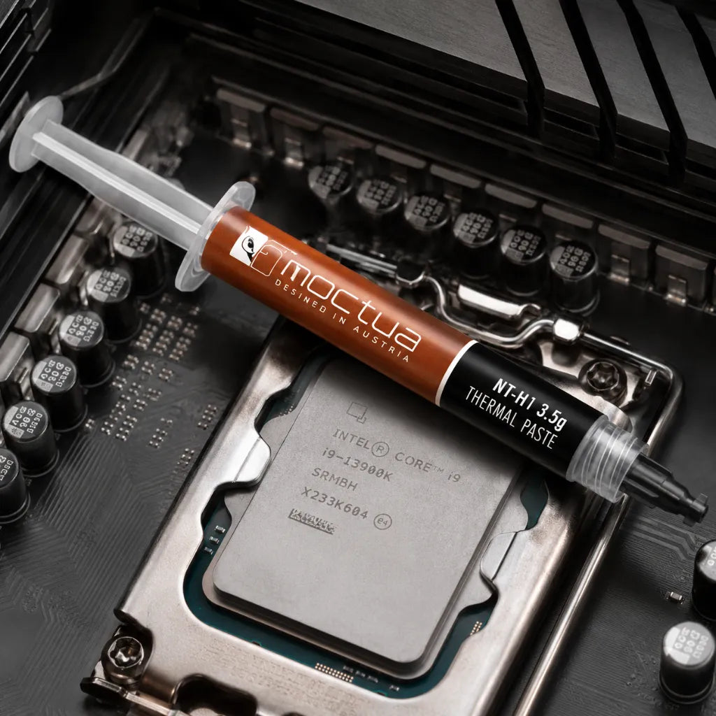 Noctua NT-H1 3.5g thermal paste syringe placed on an Intel desktop processor inside a motherboard.