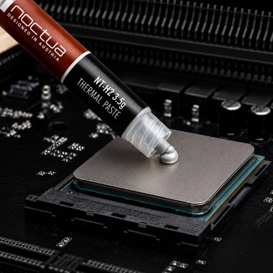 Noctua NT-H2 3.5g thermal paste being applied to a desktop processor for efficient CPU cooling.
